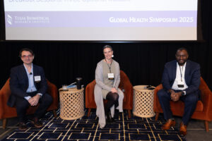 Two men and one woman seated on stage.