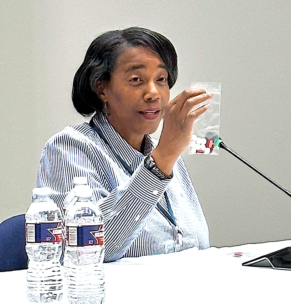 Dr. Lisa Armitige holds up a small baggie that shows how many pills a patient with TB typically takes.