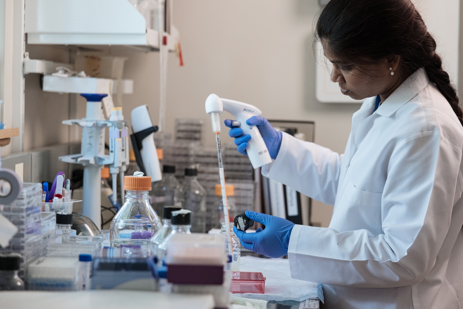 Young woman using a pipet in a research lab