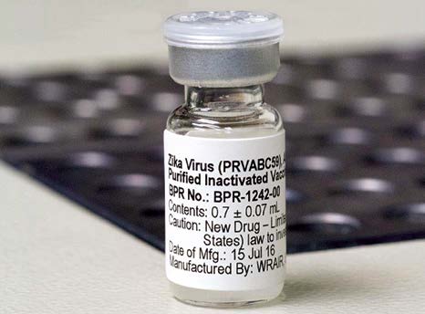 Vaccine bottle in front of keyboard Vaccine bottle in front of keyboard